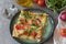 Top two pieces of tarte with appetizing rocket, tomatoes, onions, mushrooms, peppers and mozzarella.