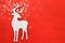 Top vie image of white wooden christmas deer over red background. Flat lay.