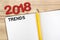 Top view of 2018 trends with blank open notebook and yellow pencil on wooden table top,Mock up for adding your content or design