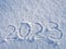 Top view on 2023 hand written on the snow. 2022 new year holiday text drawn on snow. 2022 year hand written in snow