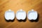 Top view of 3 white ceramic bowls of apple shape design on wood dining table background