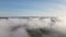 Top view from above of landscape covered with puffy morning fog. Cold humid air condensing in rain clouds