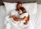 Top view of affectionate multiracial couple hugging each other while sleeping in bed