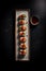 Top view ai generative image of sushi platter with soy sauce on dark background