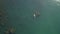 Top view from air. Sup surfer swims between algae covered rocks on supboard