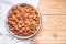 Top view of almond seeds in a bowl, on the napkin on table wooden background