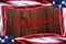 Top view of an American flags on a dark wood table forming a frame with the word Impeach in the middle