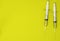 Top view of ampoules with coronavirus vaccine and syringes on yellow background. Closeup 3d concept on medical theme. 3d