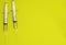 Top view of ampoules with coronavirus vaccine and syringes on yellow background. Closeup 3d concept on medical theme. 3d