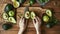 The Top View of an Anonymous Chef Carefully Cutting Ripe Avocado on a Wooden Table