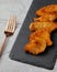 Top view of appetizing crispy fried chicken pieces with a fork