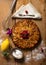 Top view of apple pie with raspberries heart over wooden board