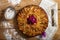 Top view of apple pie with raspberries heart over wooden board