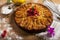 Top view of apple pie with raspberries heart over wooden board