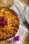 Top view of apple pie with raspberries heart over wooden board