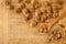 Top view of apricot pits and kernels on a rustic wooden scratched board and spoon with copy space. Healthy food background