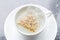 Top view of aroma chamomile tea bag floating on white teacup, re