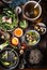 Top view of Asian food dishes. Asian noodle soup preparation on dark rustic kitchen table. Pot with stock, cooked noodles, various