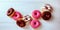 Top view of assorted doughnuts, on a white wooden background, with a copy of the space, space for text, colorful doughnuts