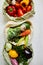 Top view assorted fresh vegetables in reusable cotton bags on table