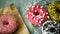 Top view of assortment of colorful frosted delicious tasty doughnuts.Pink colored sprinkle glazed donuts with marshmallow