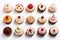 Top view of the assortment of many different cupcakes with colorful frosting and berries on white table background