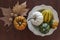 Top view of assortment of pumpkins and dry leaves on wooden table