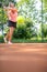 Top view of attractive young woman tennis player serving on a clay tennis court