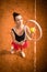 Top view of attractive young woman tennis player serving on a clay tennis court