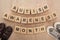 Top view of autism awareness month words made of wooden blocks near brown and grey children sneakers.