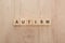 Top view of autism lettering made of wooden cubes on wooden table.