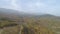 Top view of autumn misty forest in mountains. Shot. Panorama of mountains in fog and agricultural fields in autumn