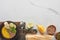 Top view of autumnal mashed pumpkin soup in bowl on wooden cutting board near bread on marble surface.