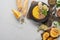 Top view of autumnal mashed pumpkin soup in bowl on wooden cutting board near pumpkin, seeds, lime and bread on marble