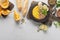 Top view of autumnal mashed pumpkin soup on wooden cutting board near ingredients and bread on marble surface.