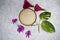 Top view of Badam milk shake, traditional Indian almond milk in transparent glass decorated with flowes and leaves in white