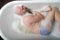 Top view of a bald man with a red beard splashing in the foam bath. Humorous photo. A parody of glamorous girls.