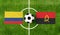 Top view ball with Colombia vs. Angola flags match on green football field