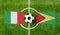 Top view ball with Italy vs. Guyana flags match on green football field