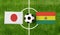 Top view ball with Japan vs. Bolivia flags match on green football field