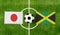 Top view ball with Japan vs. Jamaica flags match on green football field
