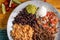 Top-view of a barbacoa burrito bowl, meat rice black beans sour cream guacamole  chopped vegetables