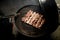 Top view of barbecue on which pieces of beef meat are fried.