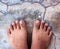 Top View of Bare Foot on Cement Floor Background.