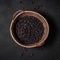 Top view of a basket full of black beans on a dark background