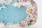 Top view of bath filled with blue bubble water, flowers and petals