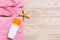 Top view of Beach flat lay accessories. sunscreen bottle with seashells, starfish, towel and flip-flop on wooden board background