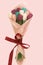 Top view of beautiful colorful tulips paper bouquet in wrapping paper on pink background. Inside every bud sweet. Handmade. A gift