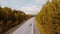 Top view of beautiful highway between woods. Stock footage. Beautiful road passing through forest area in autumn. Road