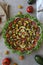 Top view of beautiful Mandala like fresh tomato, avocado, olives, lettuce and onion salad garnished with spring onion & nigella se